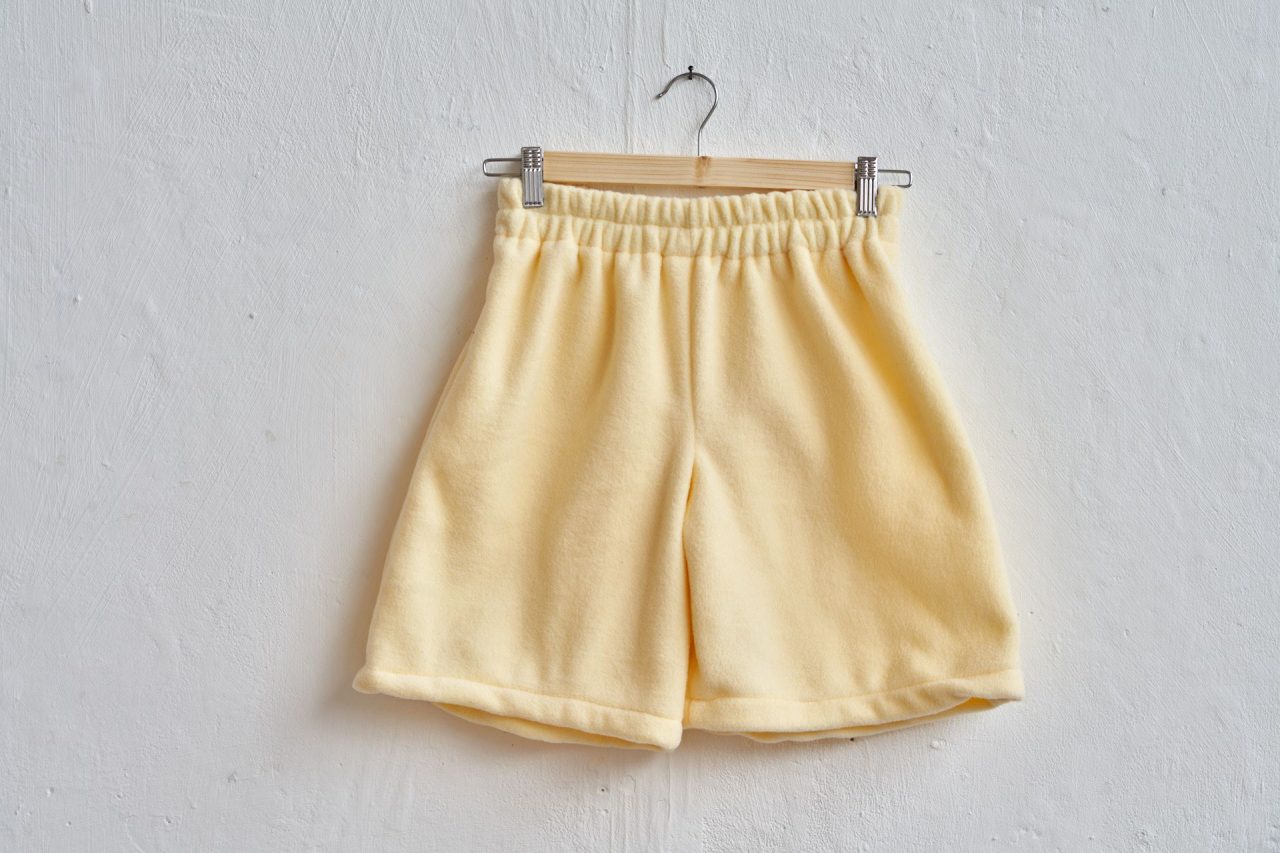 yellow fleece jogger shorts made from my own pattern hanging on a wall