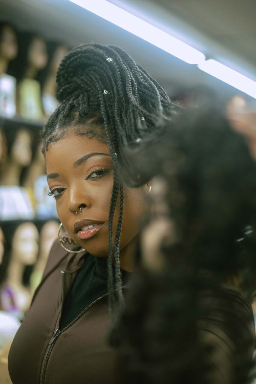Woman in hair shop embracing her braids